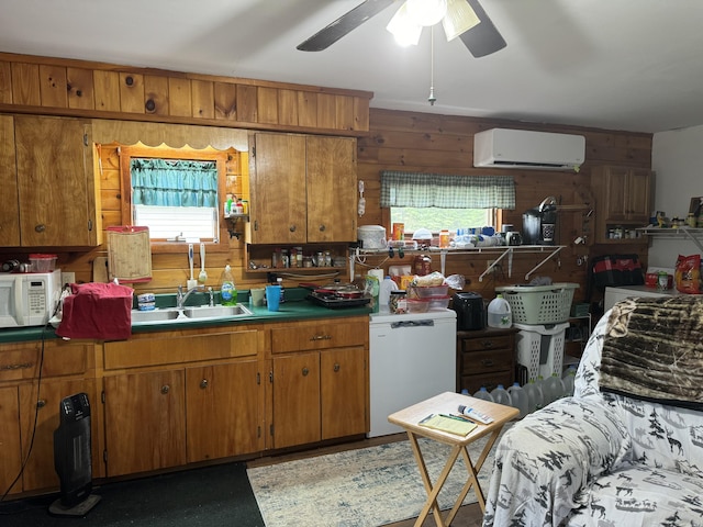 kitchen featuring an AC wall unit, sink, plenty of natural light, wood walls, and fridge