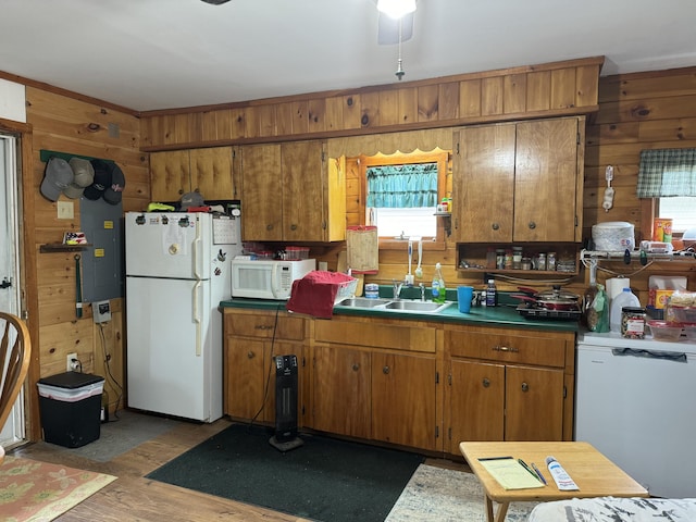 kitchen featuring ceiling fan, sink, white appliances, and wooden walls