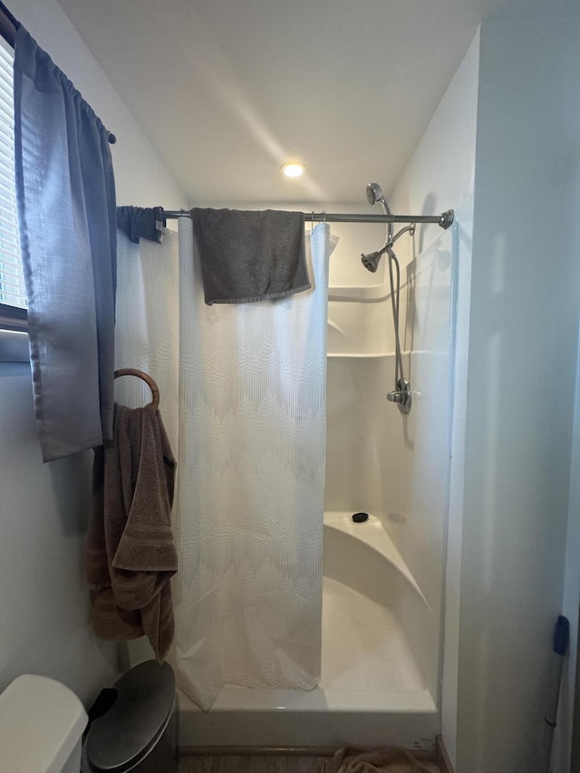 bathroom featuring toilet and curtained shower