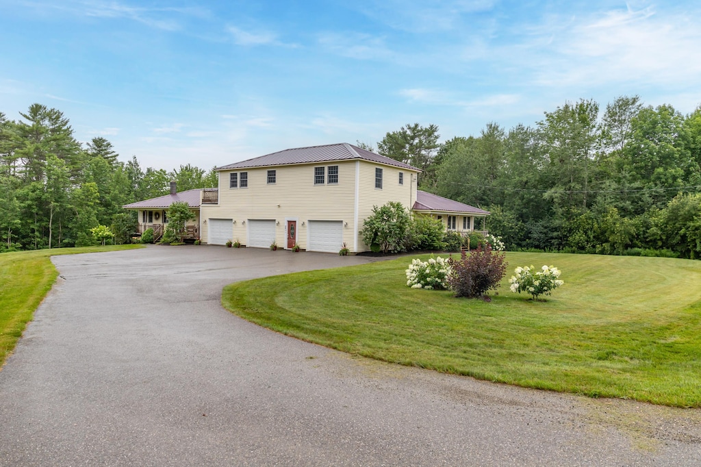 25 Meadow Rd, Winterport, ME 04496 - view of home's exterior with a garage, driveway, a lawn, and metal roof