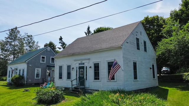 rear view of property featuring a yard