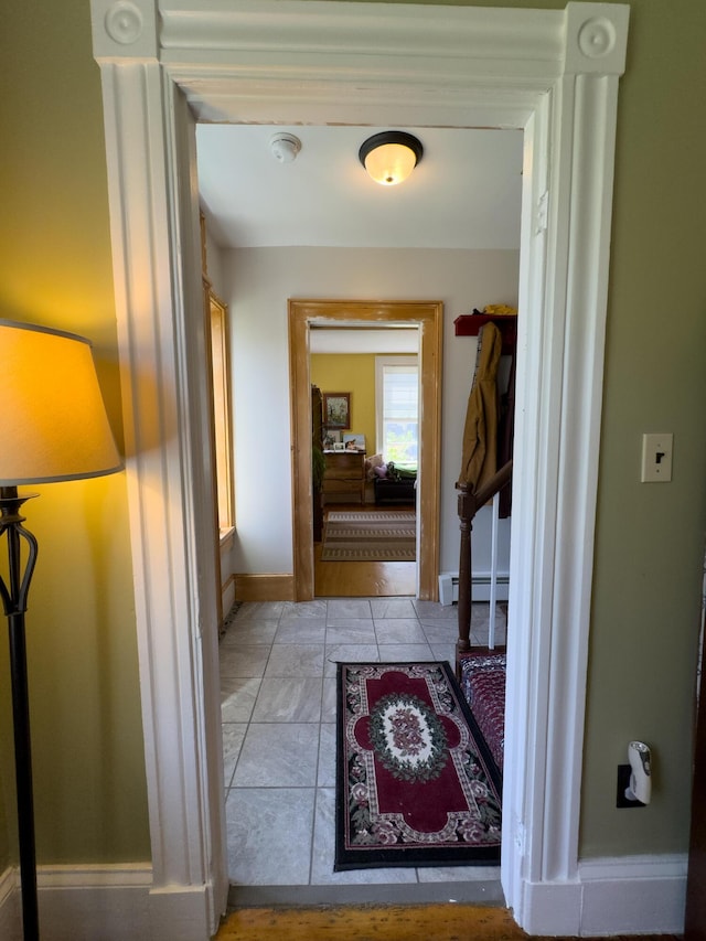 hall featuring light tile patterned floors and baseboard heating