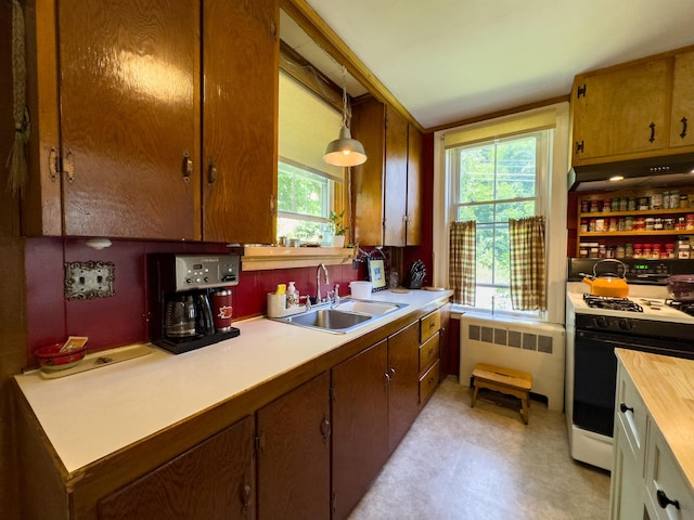 kitchen with radiator, sink, plenty of natural light, decorative light fixtures, and range with gas cooktop