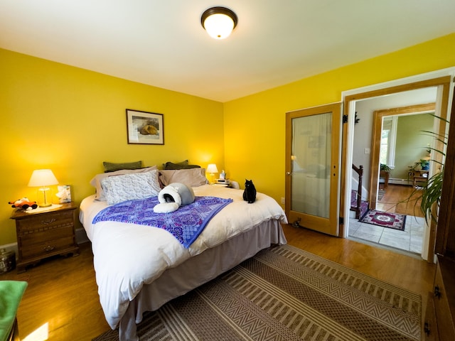 bedroom featuring baseboard heating and hardwood / wood-style floors