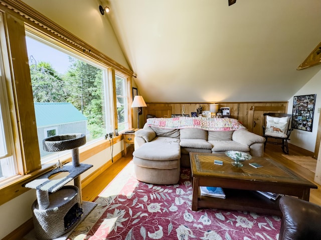 living room featuring vaulted ceiling, hardwood / wood-style floors, and wood walls