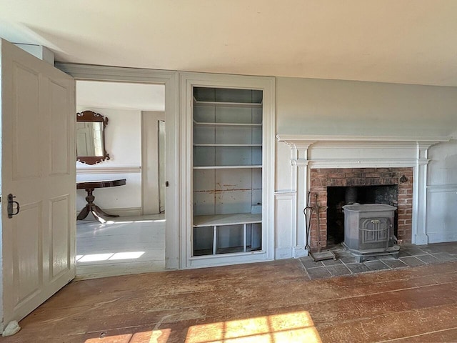 unfurnished living room with a wood stove and dark hardwood / wood-style floors