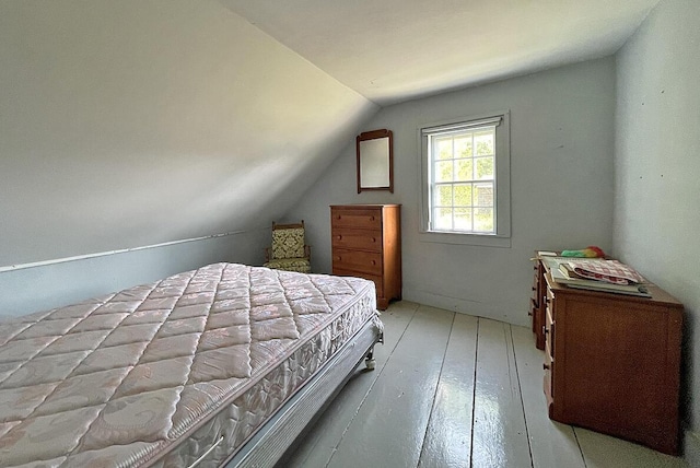 bedroom with lofted ceiling and light wood-type flooring