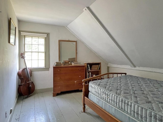 bedroom featuring lofted ceiling and light hardwood / wood-style floors