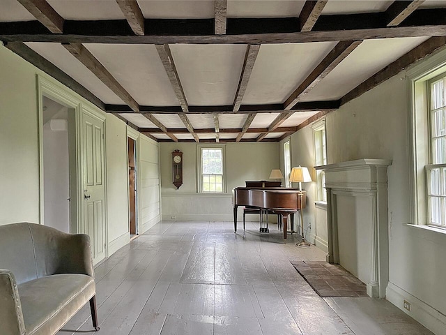 interior space with coffered ceiling, beam ceiling, and light wood-type flooring