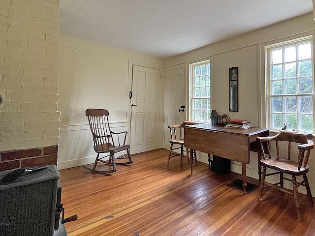 sitting room with hardwood / wood-style floors and a wood stove