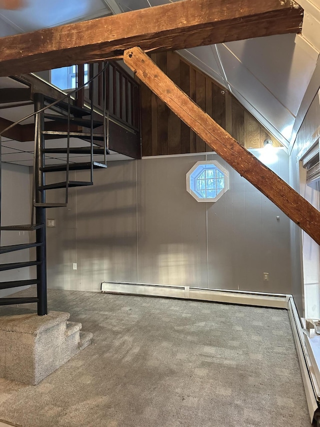 interior space featuring baseboard heating, carpet flooring, and wooden walls