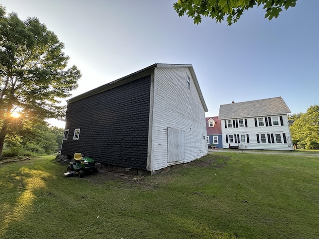 view of side of home with a yard