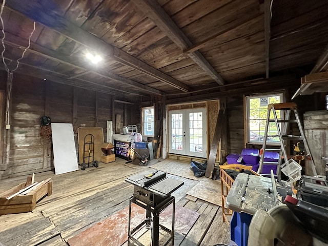 miscellaneous room featuring french doors, beamed ceiling, hardwood / wood-style floors, and wood walls