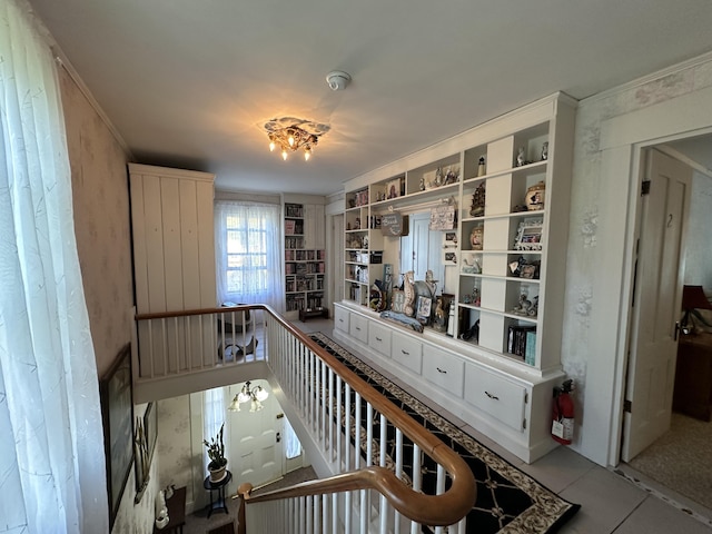 corridor featuring crown molding and light tile patterned floors