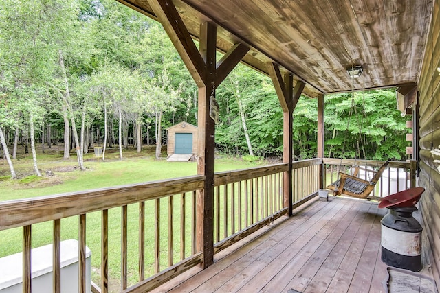 wooden deck featuring a yard and a storage shed