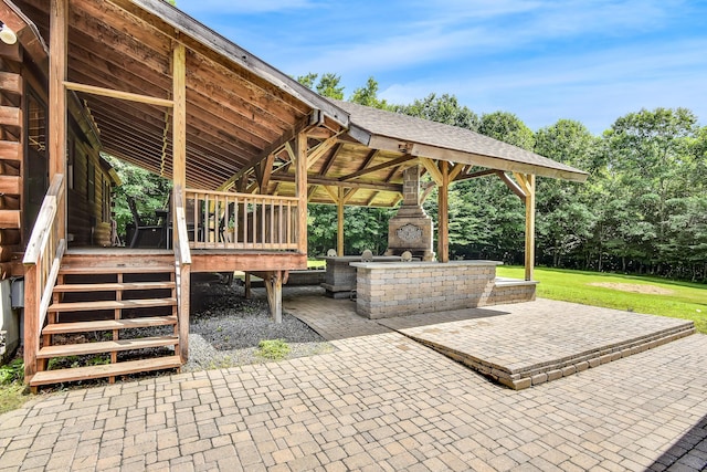 view of patio / terrace featuring an outdoor stone fireplace and a deck