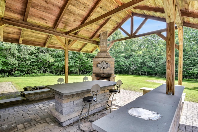view of patio featuring a gazebo and an outdoor stone fireplace