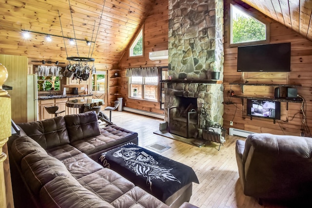 living room featuring wood walls, light wood-type flooring, wood ceiling, and a baseboard heating unit