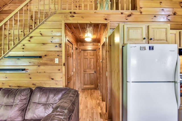 kitchen featuring wood walls, white refrigerator, wood ceiling, and light hardwood / wood-style flooring