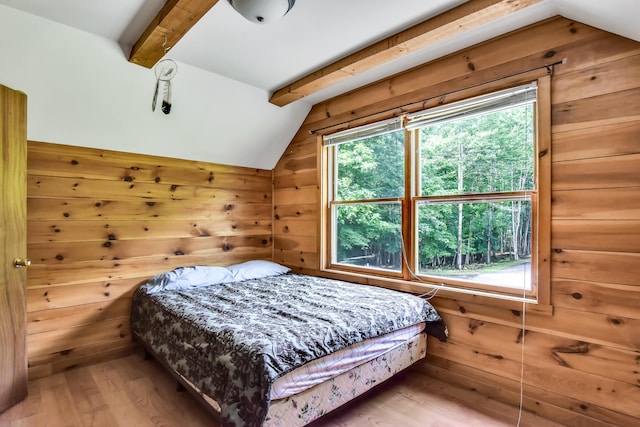 bedroom featuring wood walls, lofted ceiling with beams, and hardwood / wood-style flooring