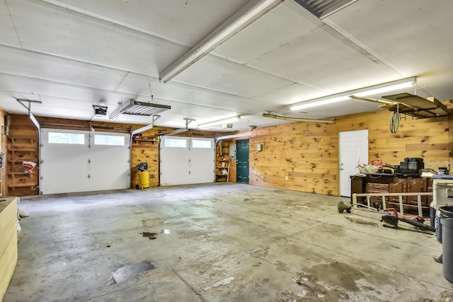garage featuring a garage door opener and wood walls