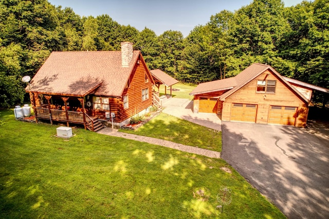 view of front of home featuring a garage, an outbuilding, and a front yard