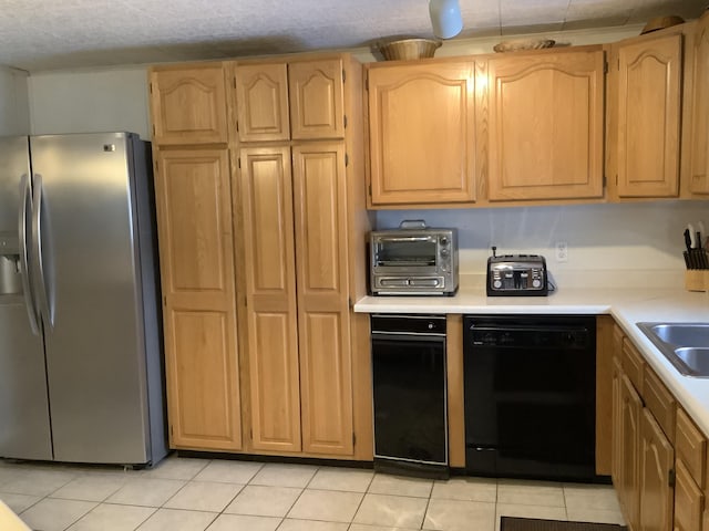 kitchen featuring light brown cabinets, stainless steel fridge, dishwasher, and light tile patterned flooring