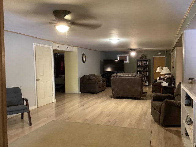 living room featuring light hardwood / wood-style floors, crown molding, and ceiling fan