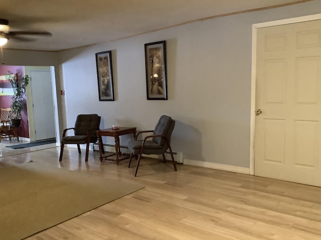 living area with light hardwood / wood-style floors and ceiling fan