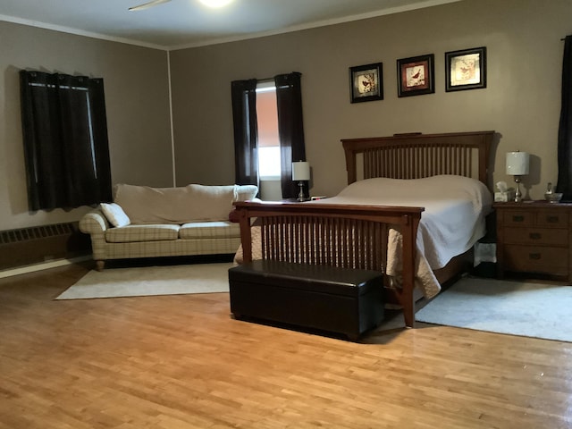 bedroom with ceiling fan, light wood-type flooring, and crown molding