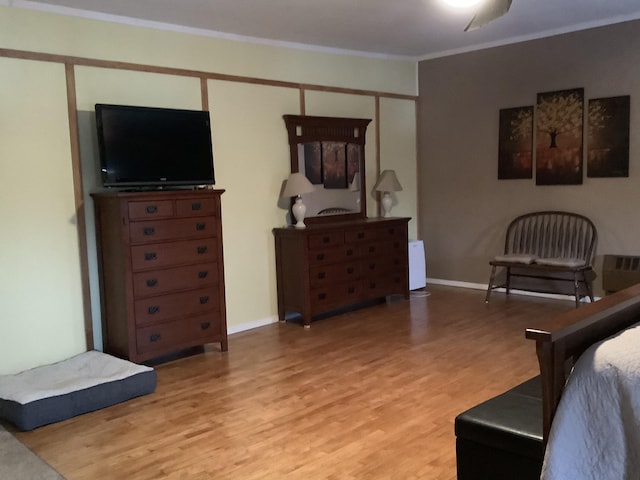 bedroom with crown molding, light hardwood / wood-style flooring, and a closet