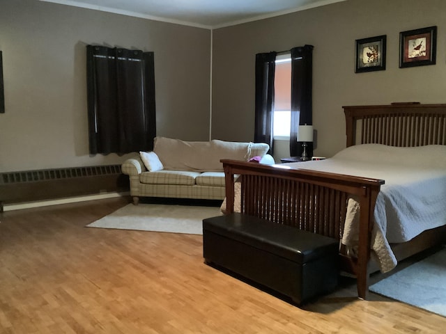 bedroom featuring ornamental molding, wood-type flooring, and radiator heating unit