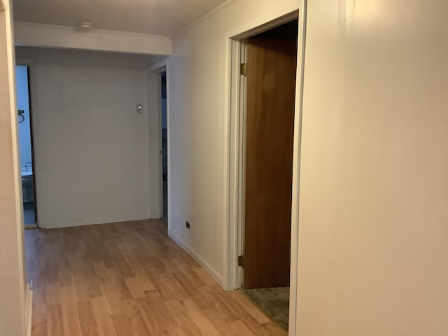 corridor featuring ornamental molding and light hardwood / wood-style floors