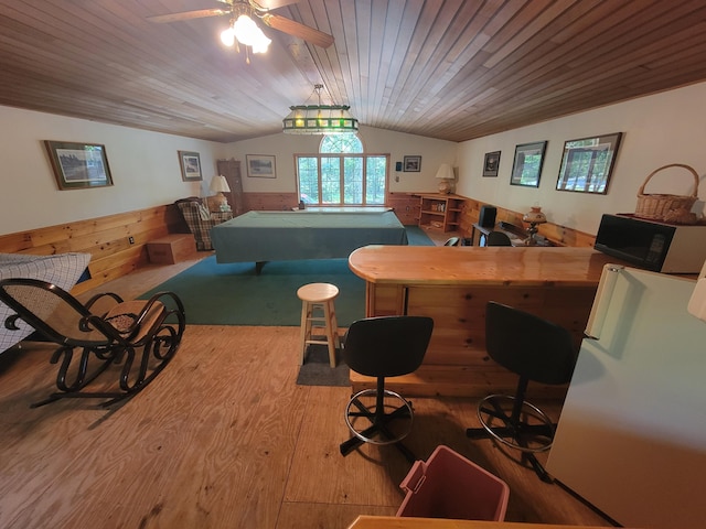 recreation room featuring vaulted ceiling, hardwood / wood-style floors, wood walls, ceiling fan, and wooden ceiling