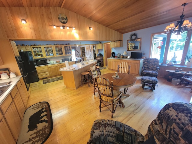 kitchen featuring lofted ceiling, wood ceiling, a center island, light wood-type flooring, and pendant lighting