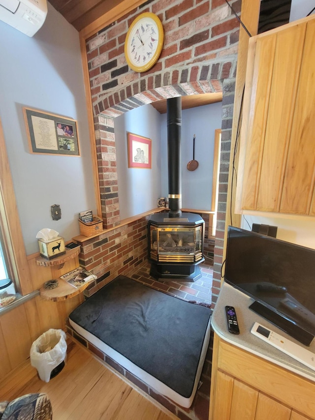 room details featuring a wall mounted air conditioner, hardwood / wood-style floors, and a wood stove