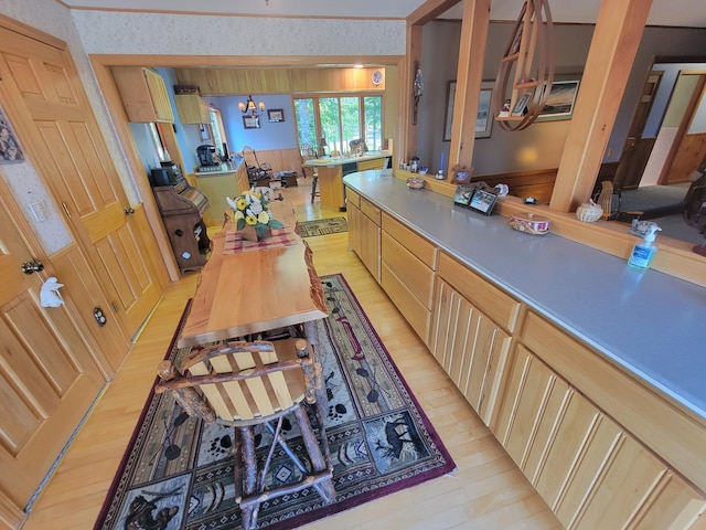 kitchen with a chandelier, light brown cabinetry, and light hardwood / wood-style floors