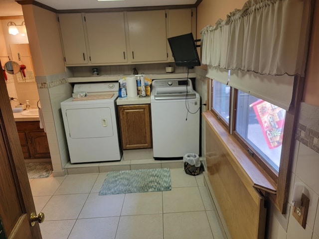 laundry area with cabinets, independent washer and dryer, sink, and light tile patterned floors