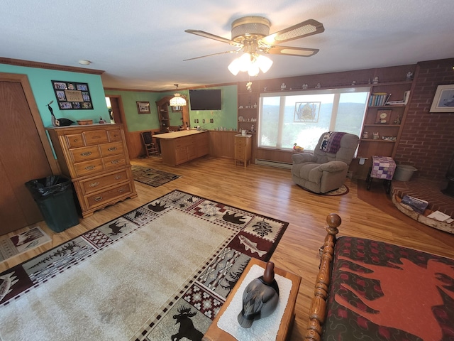 living room featuring a baseboard radiator, hardwood / wood-style floors, ceiling fan, and crown molding