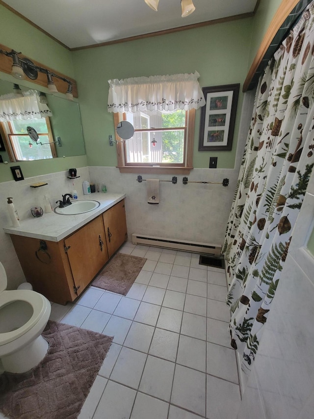 bathroom featuring tile walls, vanity, baseboard heating, crown molding, and tile patterned floors