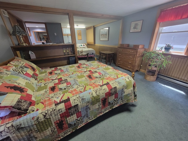 bedroom featuring a baseboard heating unit, carpet flooring, and wood walls