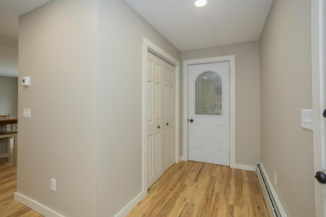 interior space featuring a baseboard heating unit and light hardwood / wood-style flooring