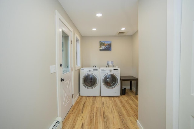 washroom featuring washing machine and dryer and light hardwood / wood-style flooring