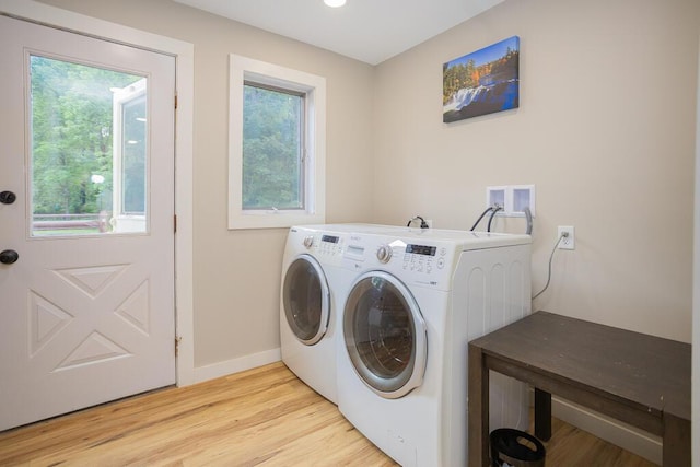 washroom featuring plenty of natural light, light hardwood / wood-style flooring, and washing machine and clothes dryer