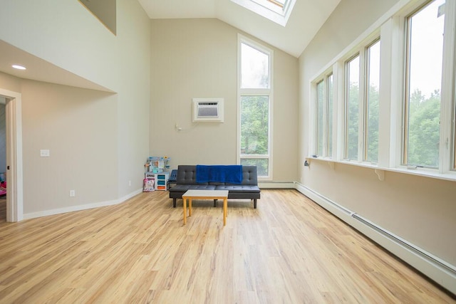 sitting room featuring an AC wall unit, a baseboard radiator, lofted ceiling with skylight, and light wood-type flooring