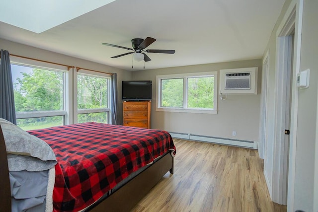 bedroom with an AC wall unit, a baseboard radiator, ceiling fan, and light hardwood / wood-style floors