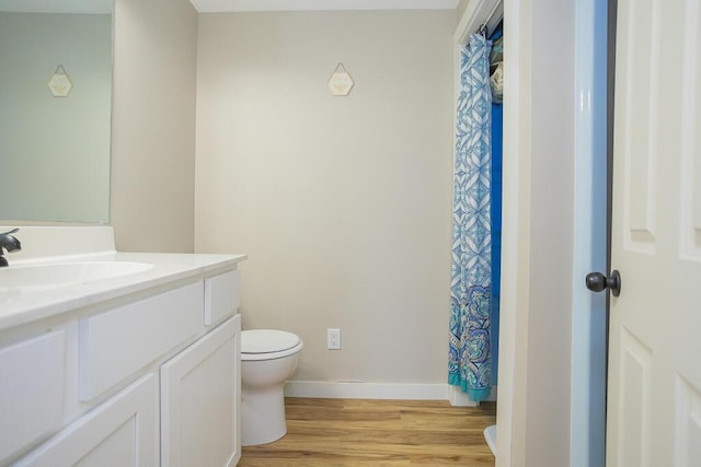 bathroom with hardwood / wood-style flooring, toilet, and vanity