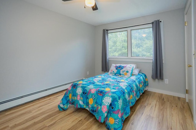 bedroom featuring ceiling fan, baseboard heating, and hardwood / wood-style floors