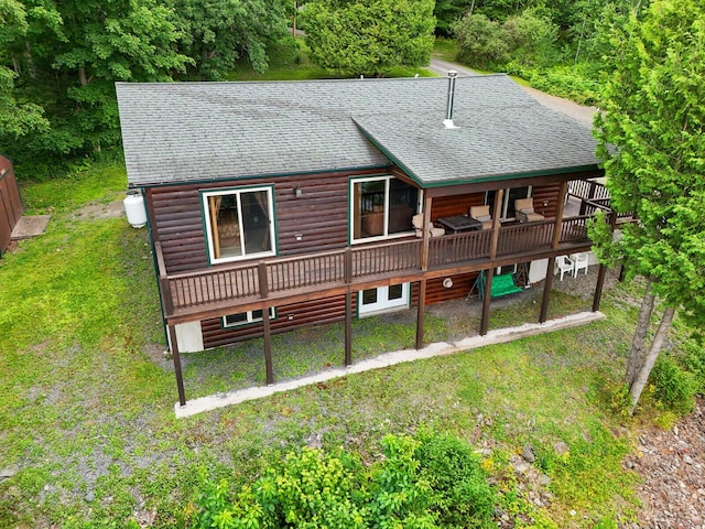 back of house featuring a lawn and a wooden deck