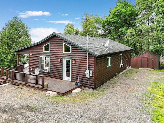 back of property featuring cooling unit, a deck, and a storage shed